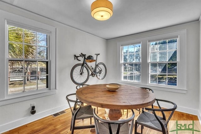 dining room featuring visible vents, baseboards, and wood finished floors