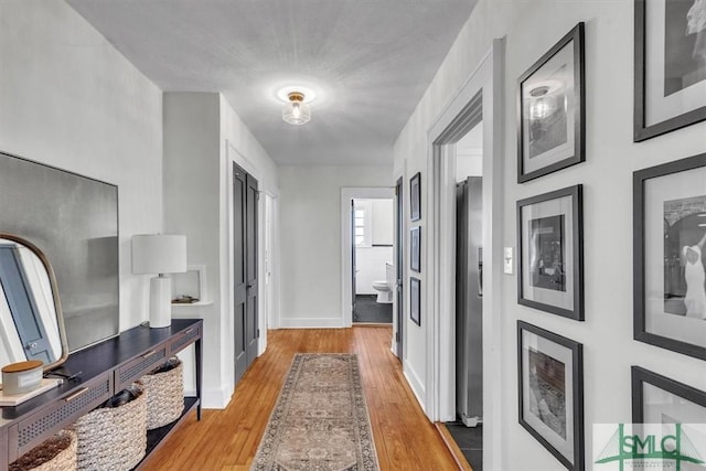 hallway featuring baseboards and wood finished floors