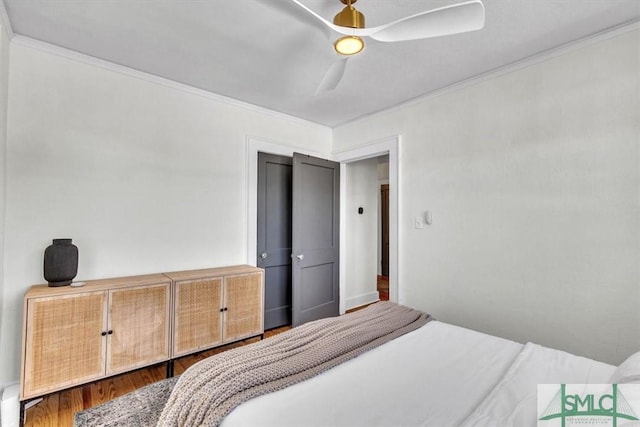 bedroom featuring a ceiling fan, crown molding, and wood finished floors