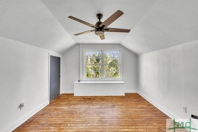 additional living space with lofted ceiling, wood finished floors, a ceiling fan, and baseboards