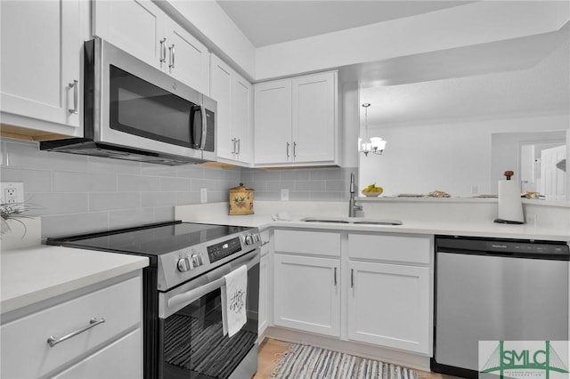 kitchen featuring a sink, white cabinetry, light countertops, appliances with stainless steel finishes, and decorative backsplash