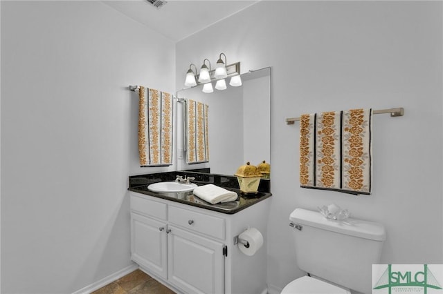 bathroom with vanity, toilet, and baseboards