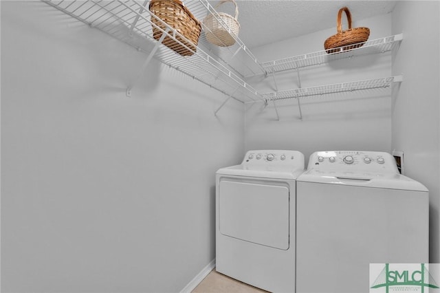 laundry room with laundry area, washing machine and dryer, and baseboards