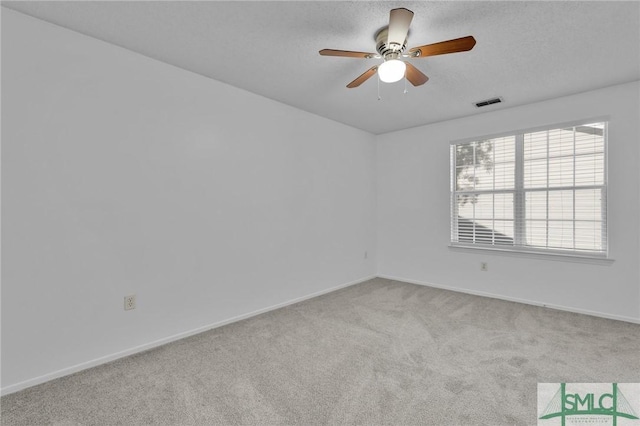 unfurnished room featuring carpet floors, ceiling fan, baseboards, and a textured ceiling