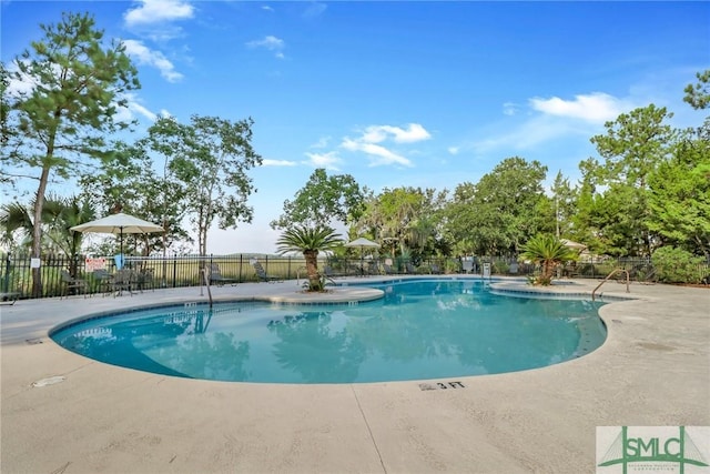 community pool featuring fence and a patio