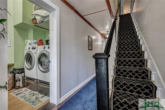 interior space with washing machine and dryer, baseboards, and wood finished floors