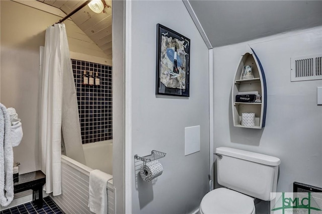 bathroom featuring vaulted ceiling, shower / bath combination with curtain, and toilet