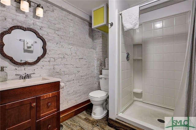 bathroom with vanity, a shower stall, toilet, and wood finished floors