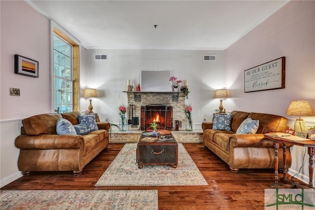 living room with dark wood-type flooring, visible vents, and crown molding