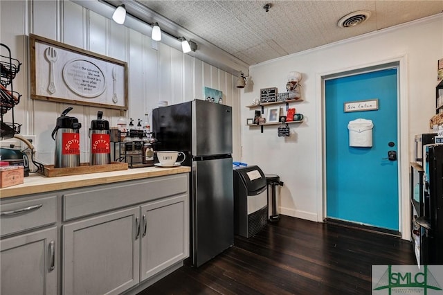 kitchen with visible vents, dark wood-style flooring, freestanding refrigerator, light countertops, and gray cabinetry