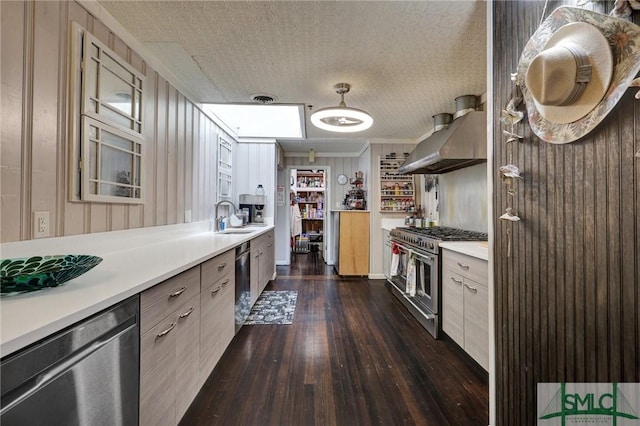 kitchen with light countertops, appliances with stainless steel finishes, dark wood-type flooring, and exhaust hood