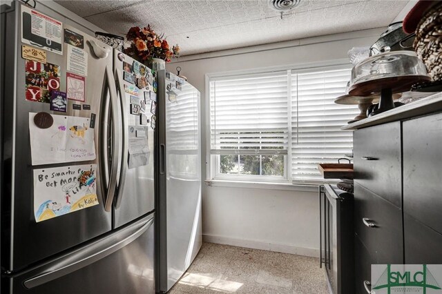 kitchen with visible vents, baseboards, and freestanding refrigerator