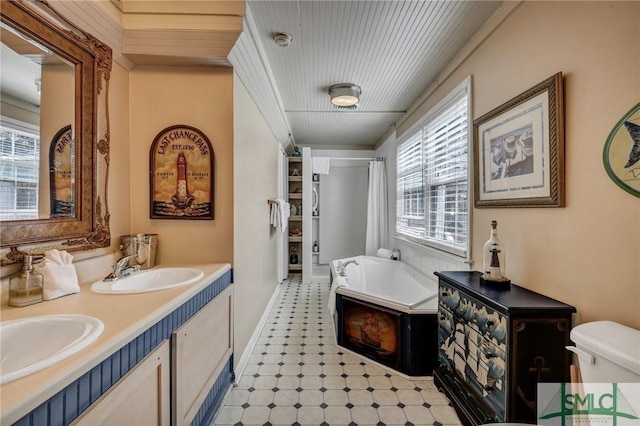 full bath with a bath, a wealth of natural light, and a sink