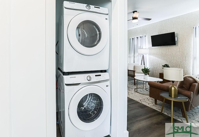 laundry room with laundry area, stacked washer / dryer, a ceiling fan, dark wood-style floors, and wallpapered walls