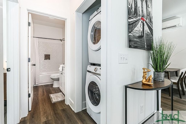 laundry room featuring laundry area, a wall unit AC, dark wood finished floors, and stacked washer / drying machine