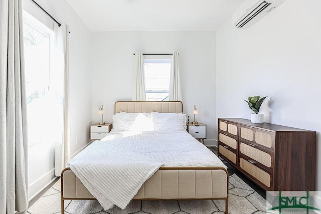 bedroom with an AC wall unit and baseboards