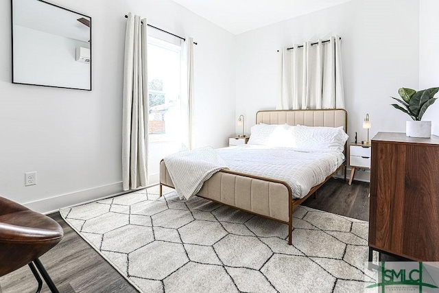 bedroom with wood finished floors and baseboards