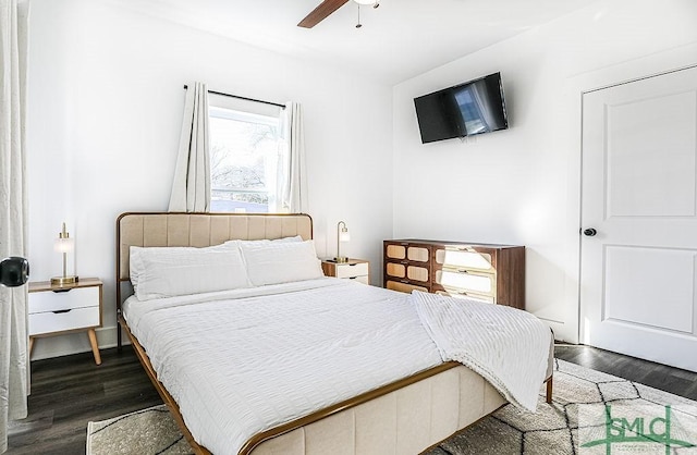 bedroom featuring ceiling fan, multiple windows, and dark wood finished floors