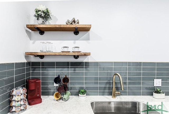 room details with open shelves, light stone counters, a sink, and tasteful backsplash