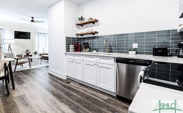 kitchen with white cabinets, backsplash, dark wood-style flooring, stainless steel dishwasher, and a sink