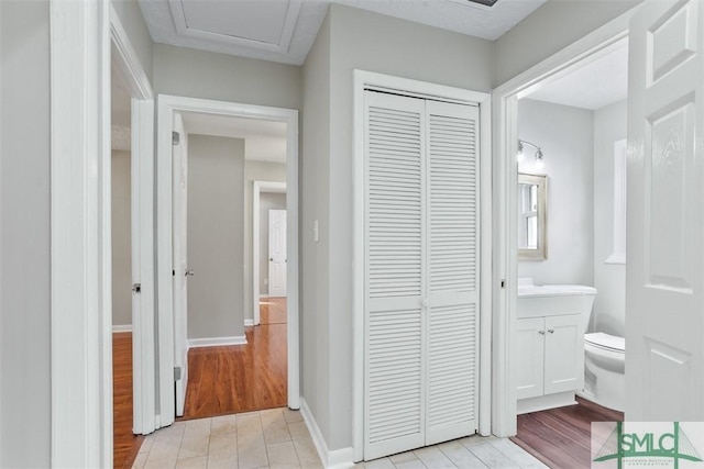 bathroom with wood finished floors, a closet, vanity, and toilet