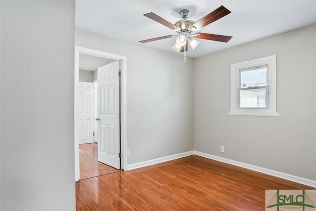 unfurnished room with ceiling fan, baseboards, and wood finished floors