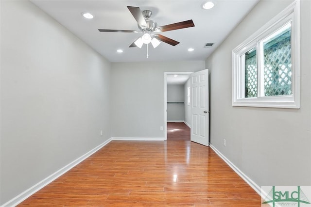 unfurnished bedroom featuring a walk in closet, recessed lighting, visible vents, light wood-type flooring, and baseboards