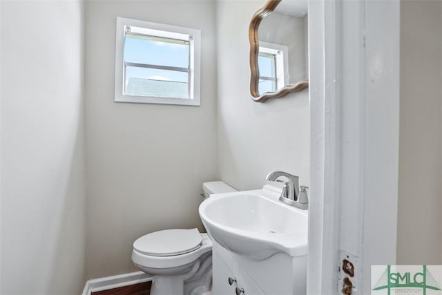 half bathroom with vanity and toilet