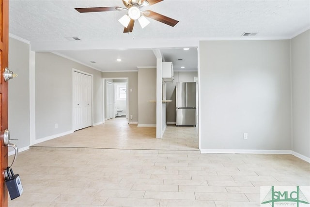 spare room featuring crown molding, ceiling fan, visible vents, and baseboards