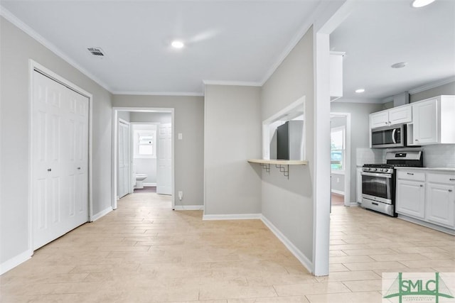 kitchen with white cabinets, plenty of natural light, stainless steel appliances, and crown molding