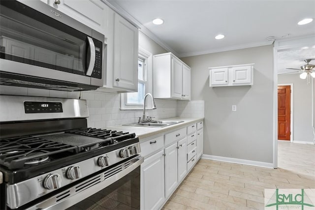 kitchen with a sink, white cabinetry, light countertops, appliances with stainless steel finishes, and decorative backsplash