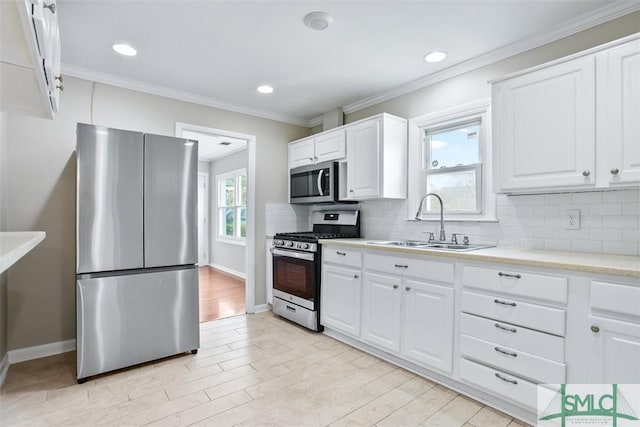 kitchen featuring stainless steel appliances, backsplash, plenty of natural light, and a sink