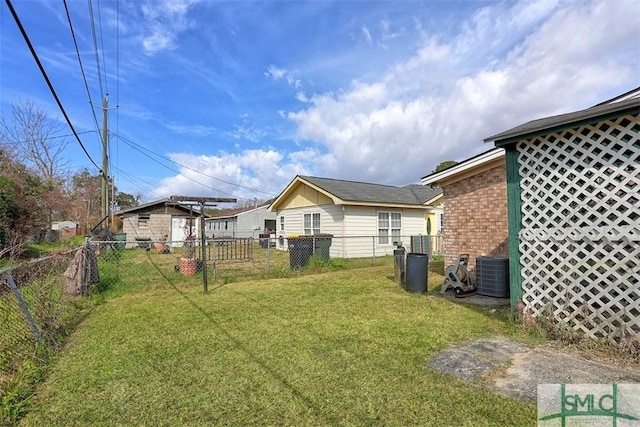 view of yard with central AC and fence