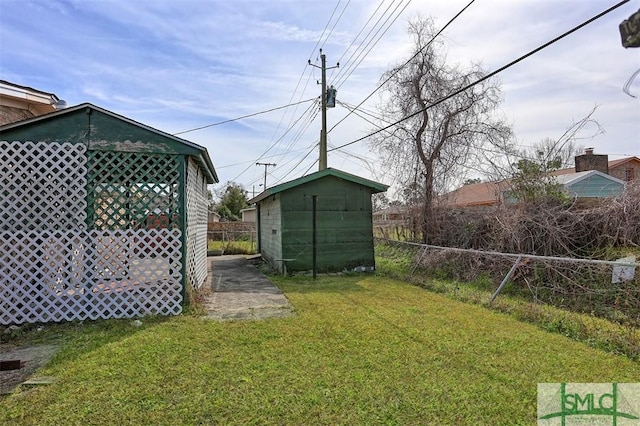 view of yard featuring an outbuilding, a fenced backyard, and a storage unit