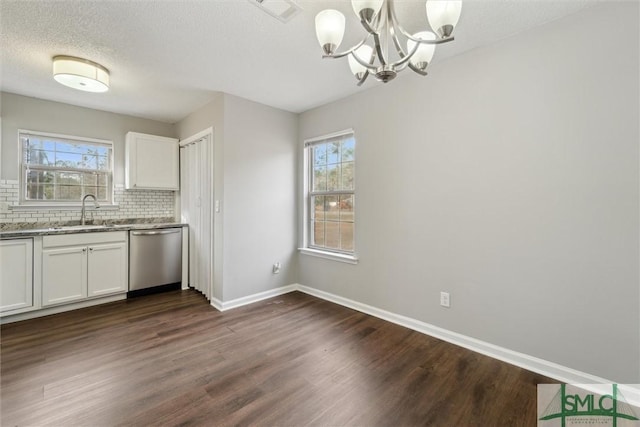 kitchen with dark wood finished floors, visible vents, decorative backsplash, stainless steel dishwasher, and a sink