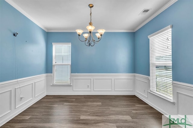 unfurnished dining area featuring visible vents, dark wood-type flooring, a notable chandelier, and ornamental molding