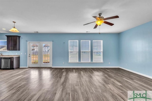 unfurnished living room with baseboards, a ceiling fan, and wood finished floors