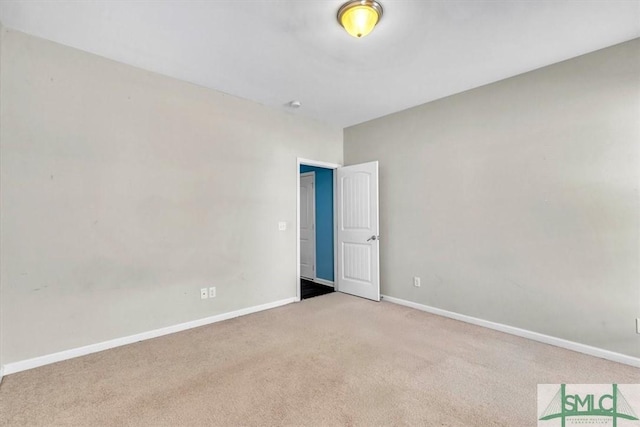 empty room featuring baseboards and carpet flooring