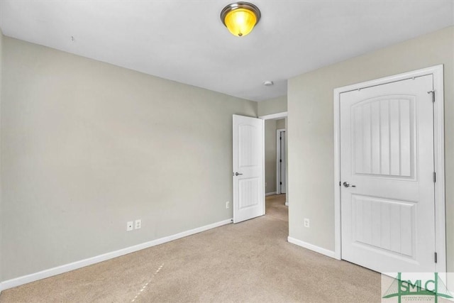 unfurnished bedroom featuring baseboards and light colored carpet