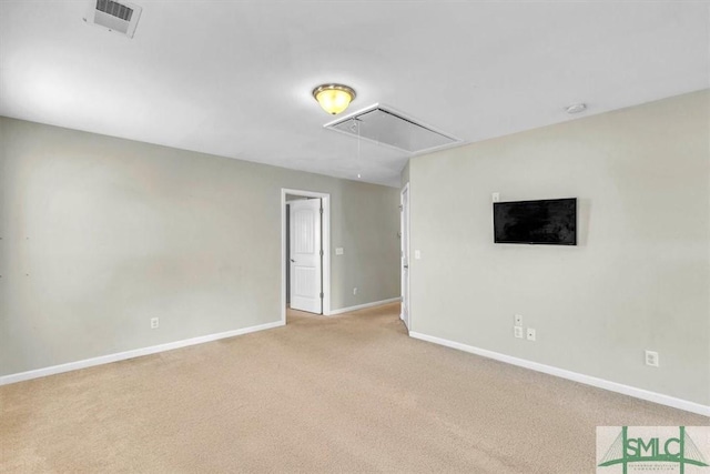 unfurnished room featuring visible vents, baseboards, carpet, and attic access
