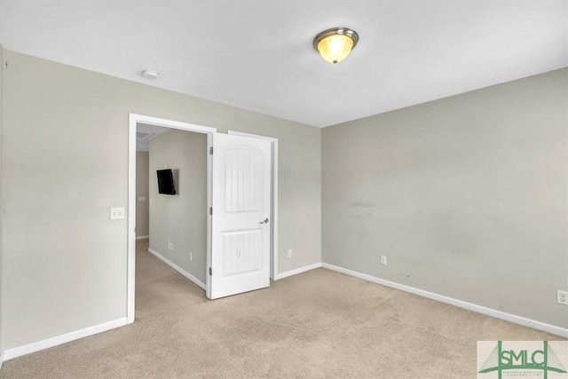 unfurnished bedroom featuring baseboards and light carpet