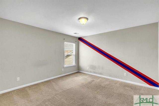 carpeted empty room featuring baseboards