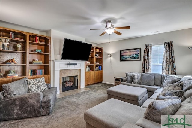 carpeted living area with baseboards, a fireplace, visible vents, and a ceiling fan