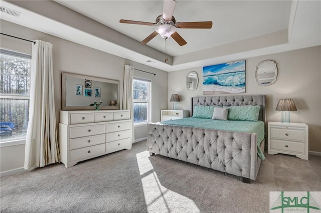 bedroom featuring carpet floors, a raised ceiling, and visible vents