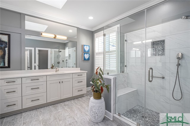 full bath featuring a skylight, a shower stall, vanity, and crown molding