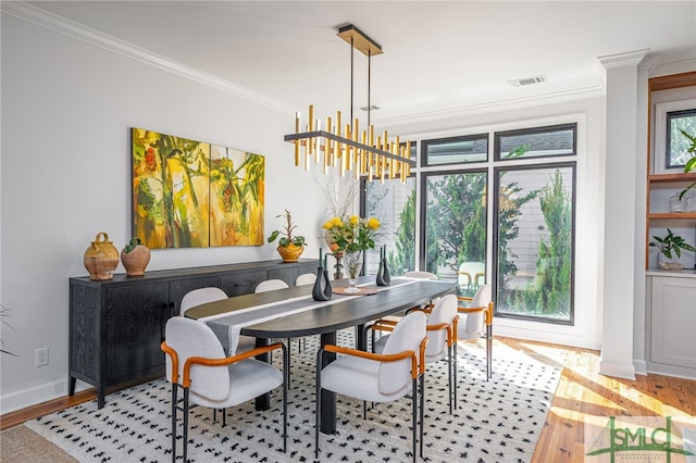 dining area with baseboards, visible vents, crown molding, and wood finished floors