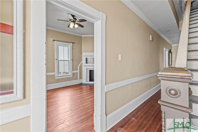 hallway with baseboards, ornamental molding, and wood finished floors