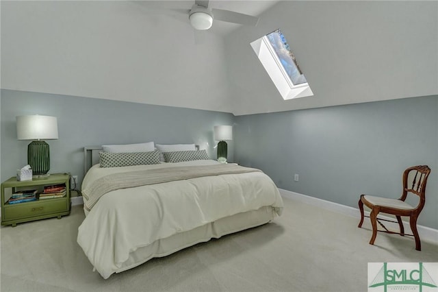 carpeted bedroom with lofted ceiling with skylight, ceiling fan, and baseboards