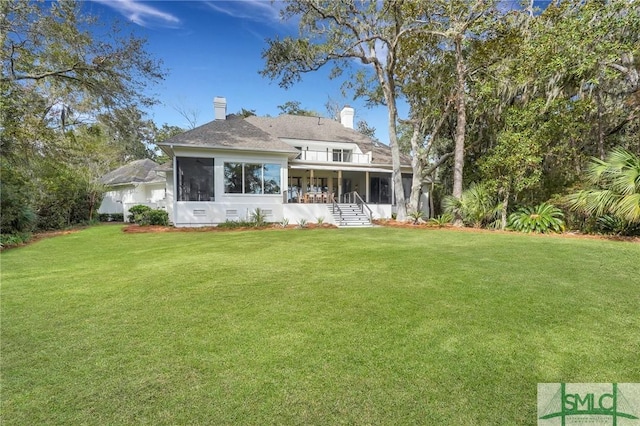 back of house with a sunroom, crawl space, a lawn, and a balcony