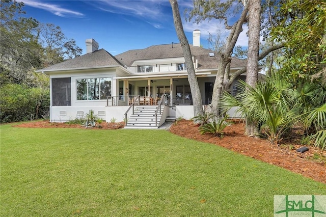 back of property featuring a chimney, crawl space, a lawn, and a balcony